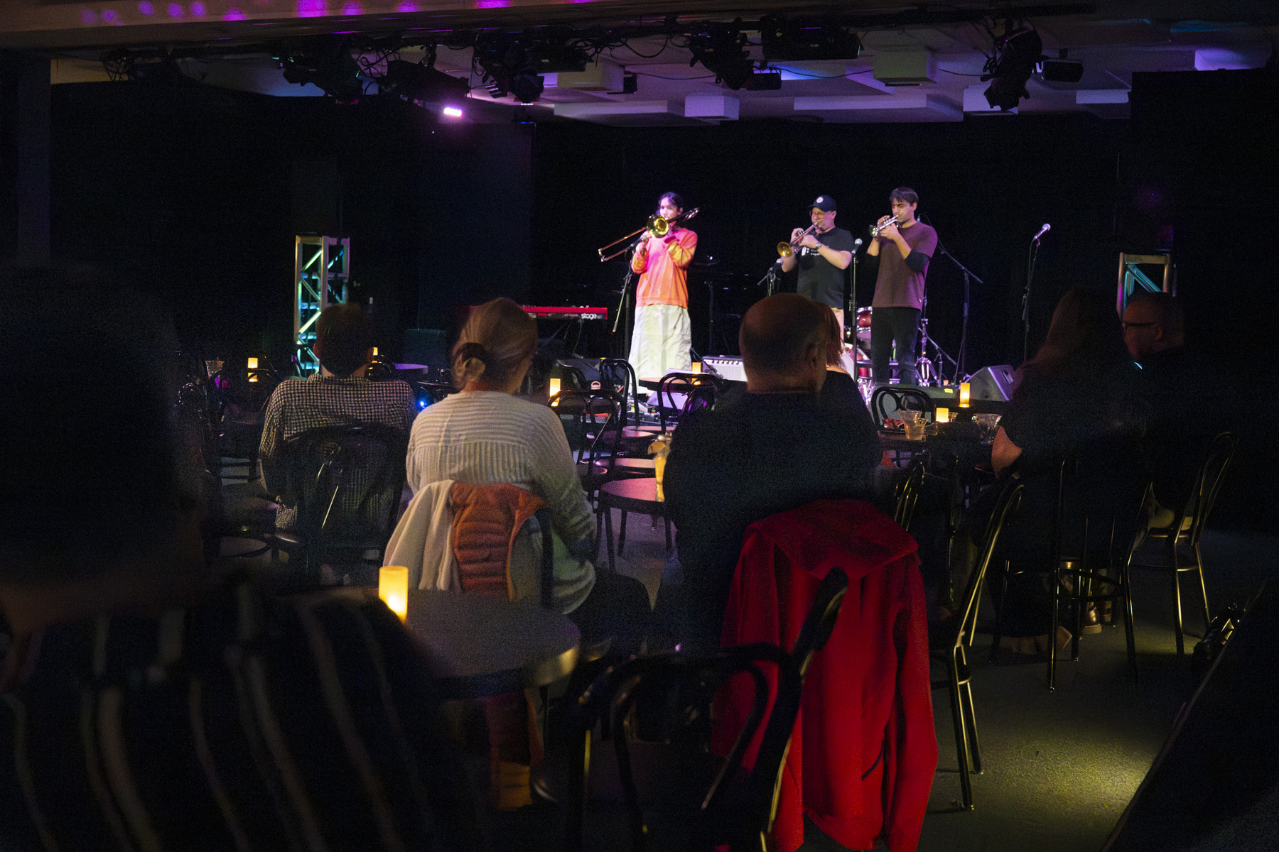 crowd setting at table and watching musical performance with lit lightning