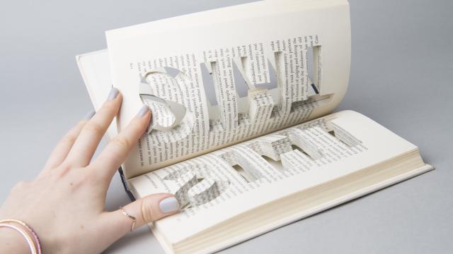 Image of hand holding open an artists' book.