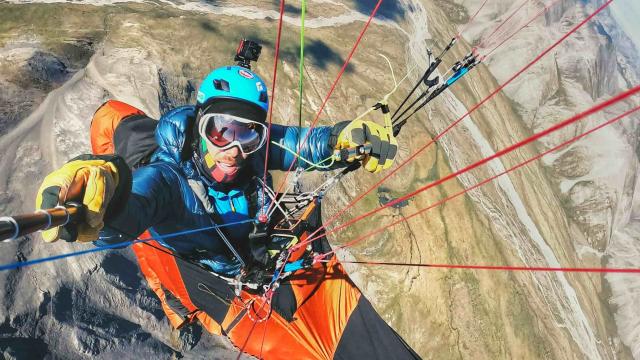 A paraglider is flying over mountains.