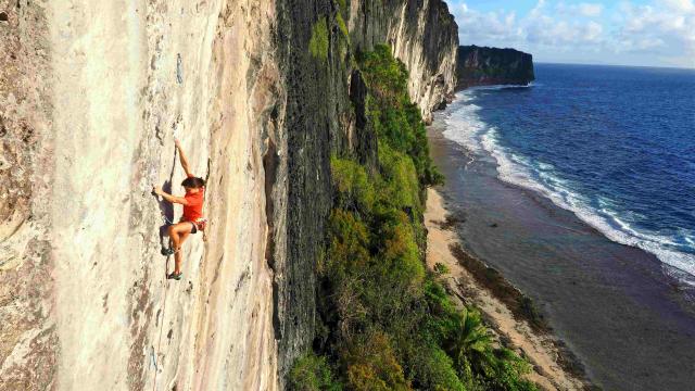 A female athlete is climbing on the coast. 