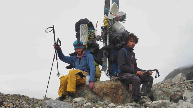 Two skiers are having a break from hiking.