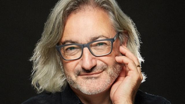 Headshot of author Gary Barwin wearing a black collared T in front of a black background.