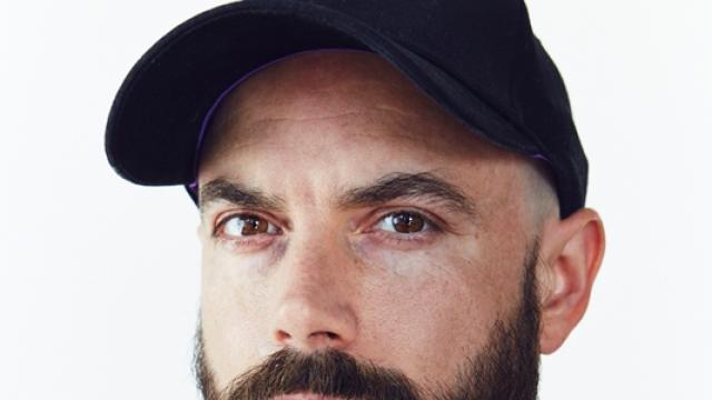 Chris Curreri Portrait staring at photographer in navy ball cap and shirt.