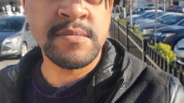 Damon Reaves wears a leather jacket over a T-shirt and is sporting a goatee and dreads.