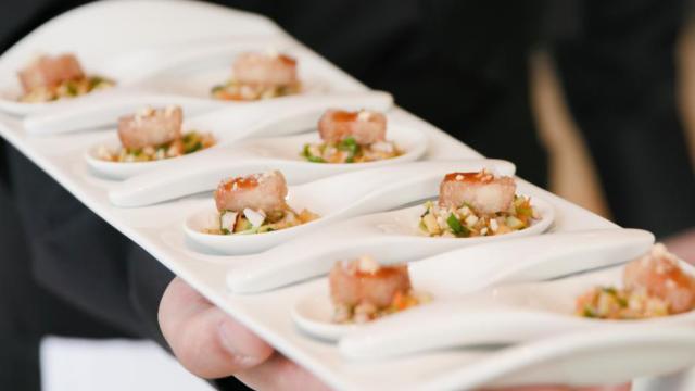 A server carrying a platter with appetizers
