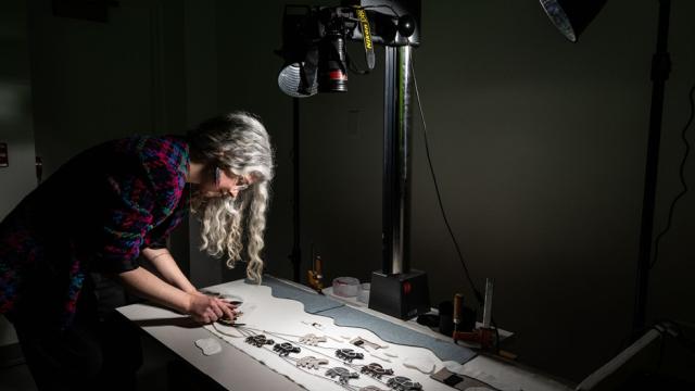 An artist is working at a table in their studio