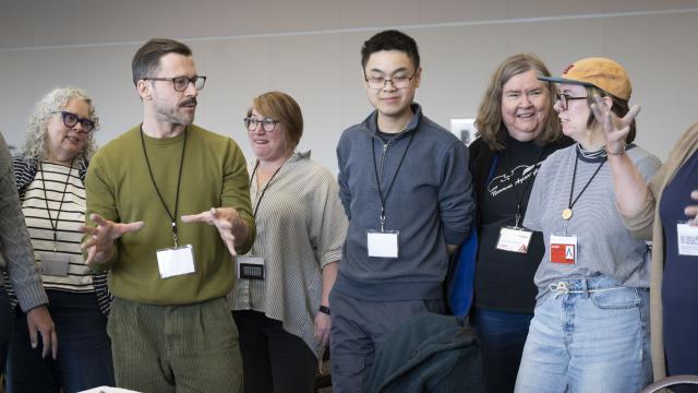 A group of people are engaged in a lively discussion in a classroom