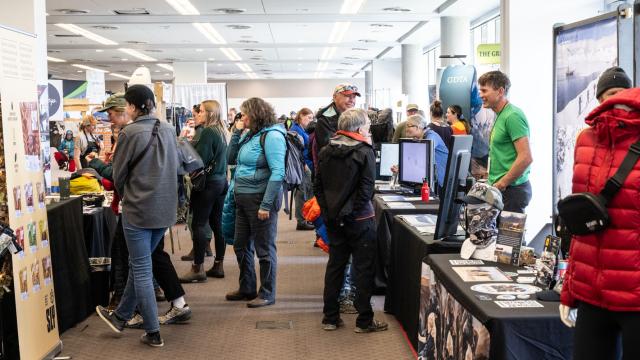 A large number of people engage with exhibitors at their booths in a crowded Marketplace?