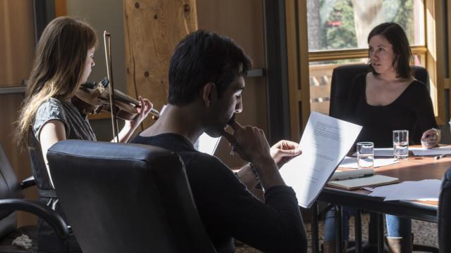 Three people are seated together in a studio
