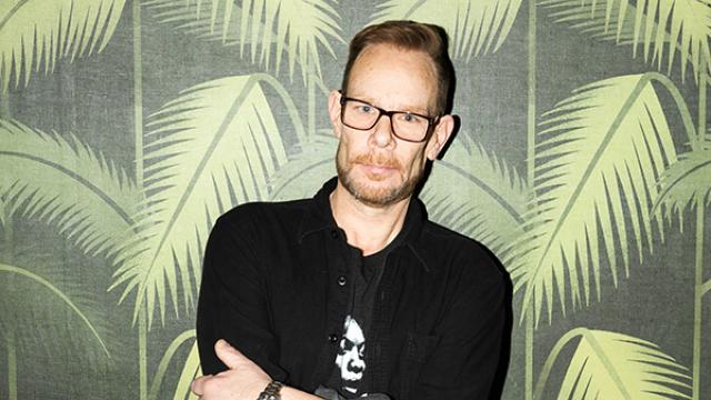 DJ Rob Faust standing against palm tree pattern wall paper