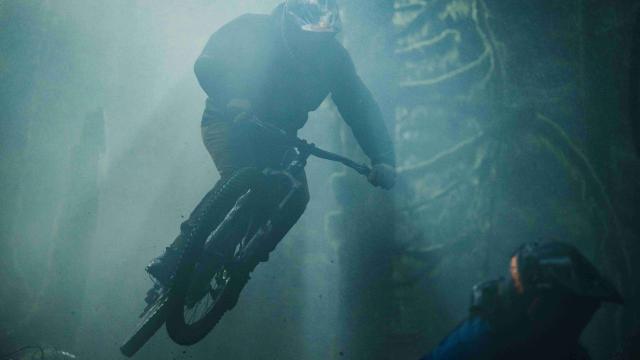 Mountain biker jumping in a dense forest