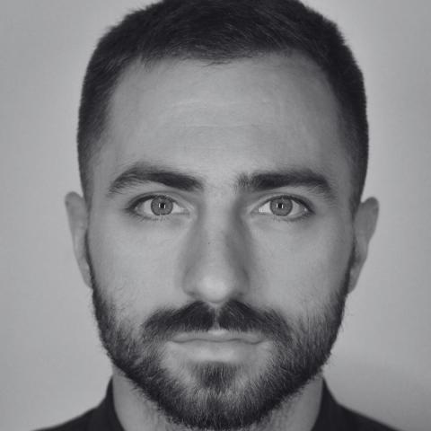 Black and white close up headshot of man with beard