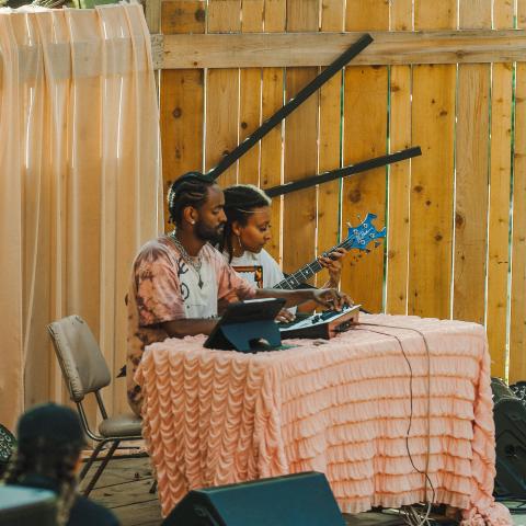 2 people sitting behind a table with instruments