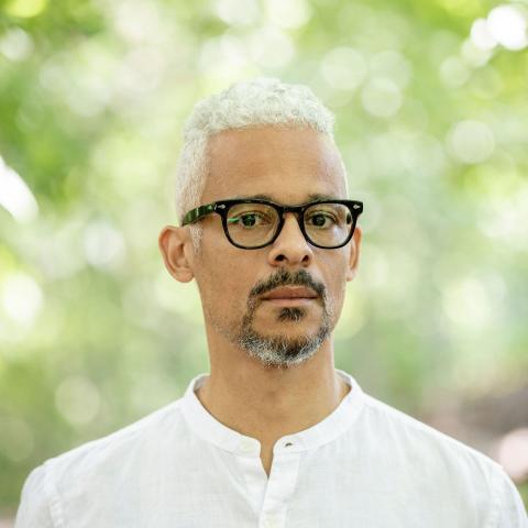 Writer Kaie Kellough with trees in the background 