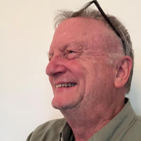 Man smiling broadly looking off to the side of 