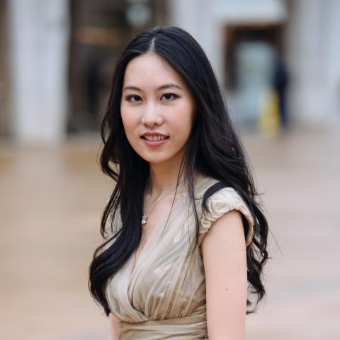 Woman in beige top and long black hair looking at the camera