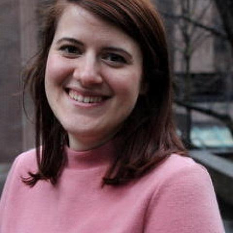 Catherine wears a pink shirt and smiles looking at the camera. 