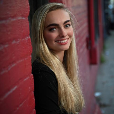 Elise Arancio standing in a door way of a red brick building