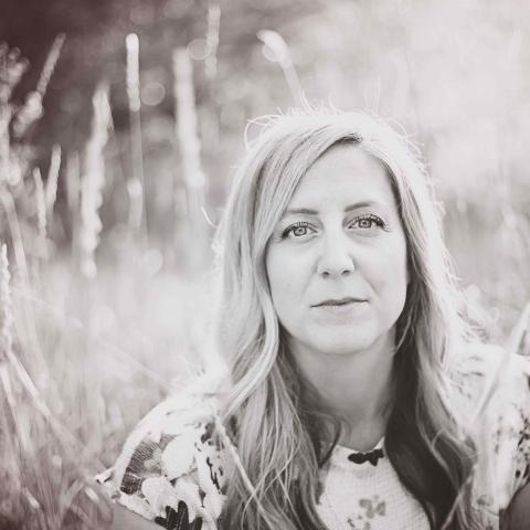 Mari Alice Conrad sitting in long grass