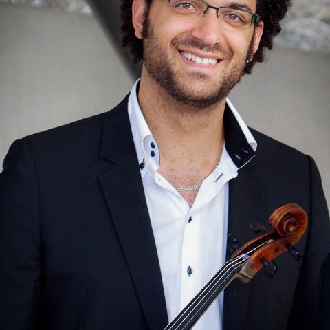 Man with glasses smiles while holding a viola