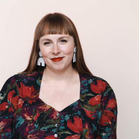 Smiling woman with bangs and a flower print dress 