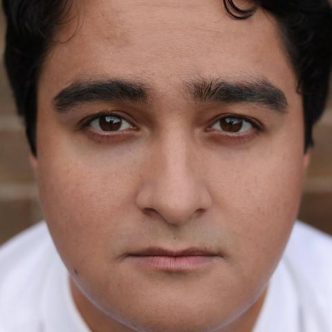 Headshot of a person in white shirt staring into camera