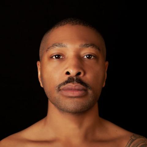 A portrait of Kyle Abraham, bare-chested