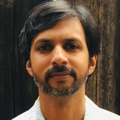 Man with short dark hair looking directly into the camera