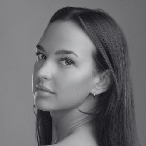 Black and white photo of woman looking at camera from the side