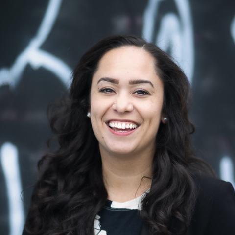 Woman with long black hair smiling broadly at camera